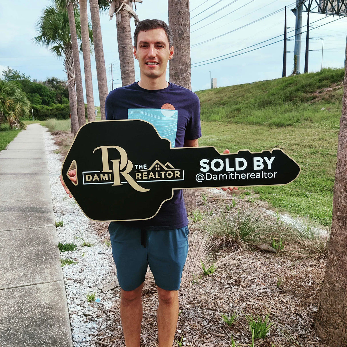 Black Key Shaped Sign with Gold text Logo "Sold by"