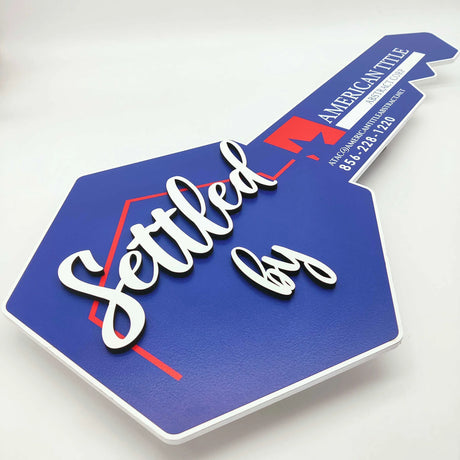 Key Shaped Sign Blue and white outline with 3D text "Settled by"